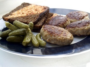 Le Frikadeller con pane di segale e un contorno di cetriolini